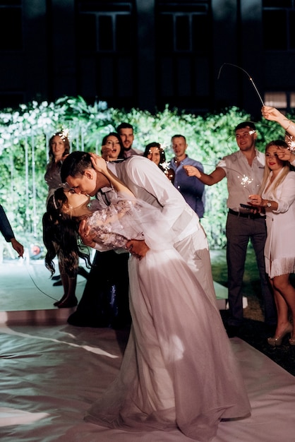 Photo sparklers at the wedding of the newlyweds in the hands of joyful guests