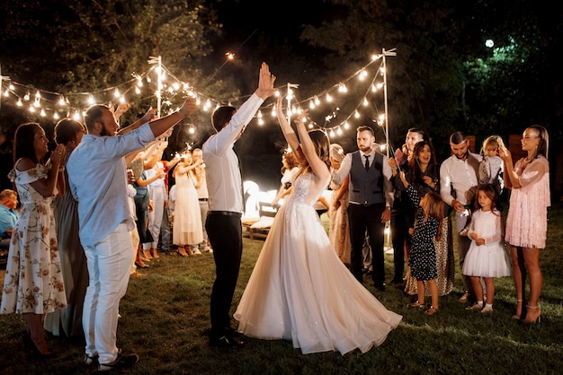 Foto sparklers al matrimonio degli sposi nelle mani di ospiti gioiosi