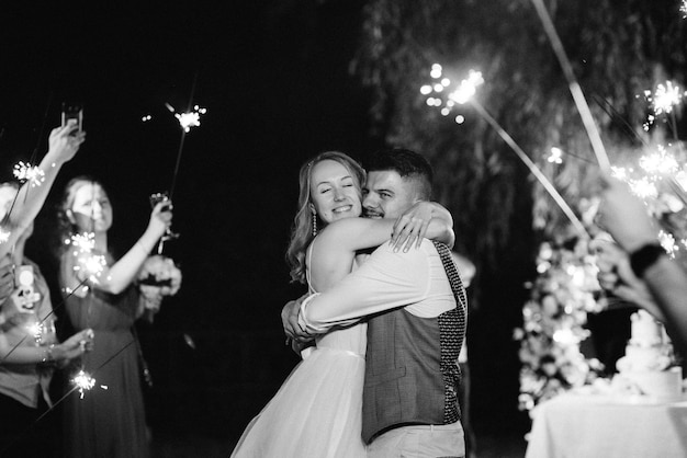 Sparklers at the wedding of the newlyweds in the hands of joyful guests