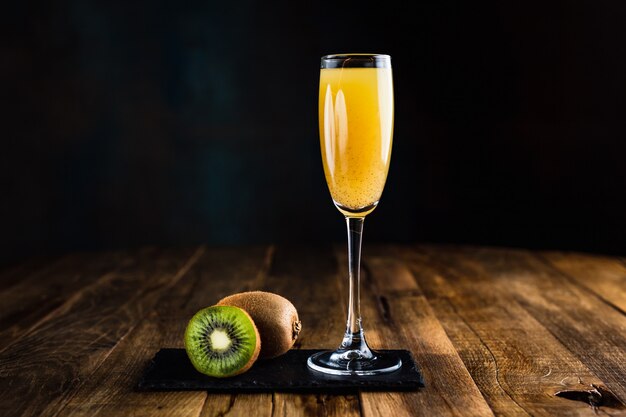 A sparkling cocktail with kiwi in a flute glass