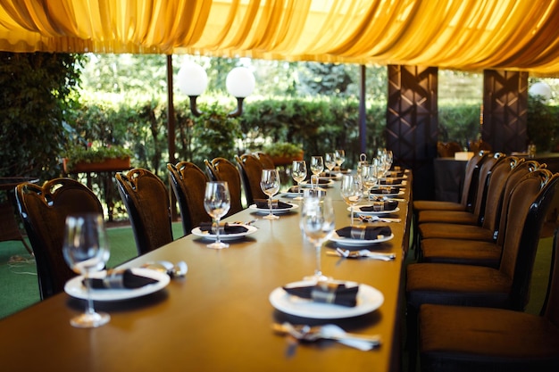 Sparkling glassware stands on long table prepared for wedding dinner