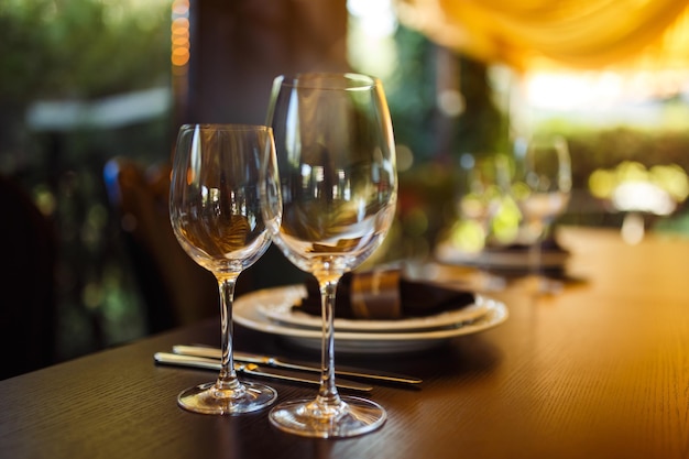 Sparkling glassware stands on long table prepared for wedding dinner