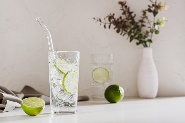 Acqua minerale frizzante con ghiaccio e lime in bicchieri per rinfrescarsi nella calura estiva