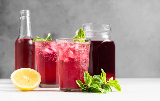 Sparkling pink lemonade with lemon and mint. Summer refreshment drink.