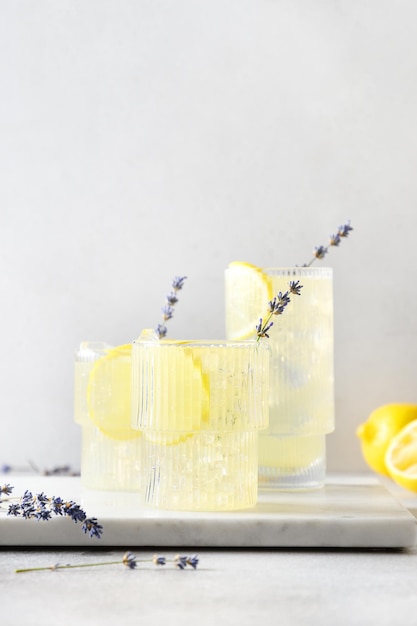 Sparkling summer lavender lemonade in glasses on gray background