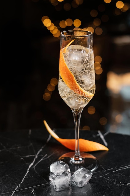 Photo sparkling wine in a glass with ice and orange zest