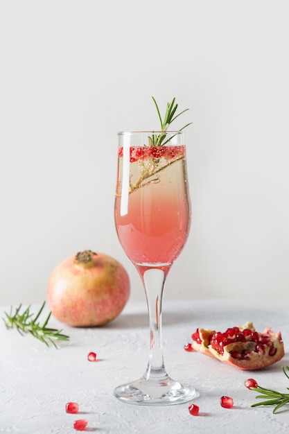 Sparkling wine, pomegranate on white table. Xmas holiday drink. Close up.