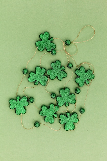 Photo sparkly clovers on a green surface for saint patricks day