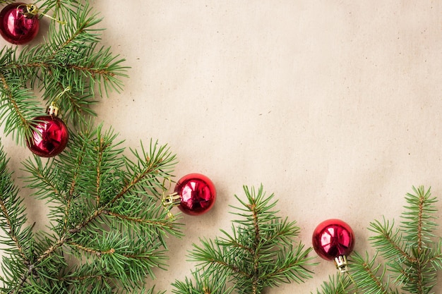 Sparrentakken versierd met rode kerstballen als rand op een rustieke vakantie achtergrond frame met kopie ruimte