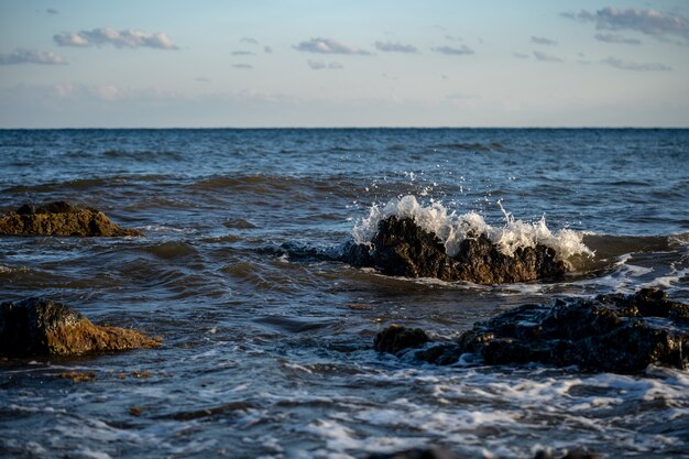 Spatten van de golven die tegen de rotsachtige kust botsen