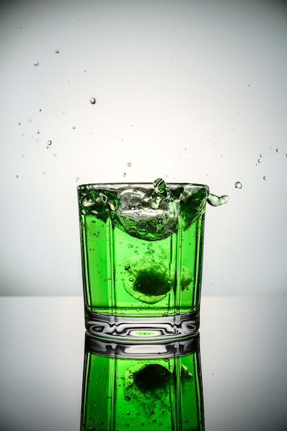 Spatten van ijs in groene cocktail