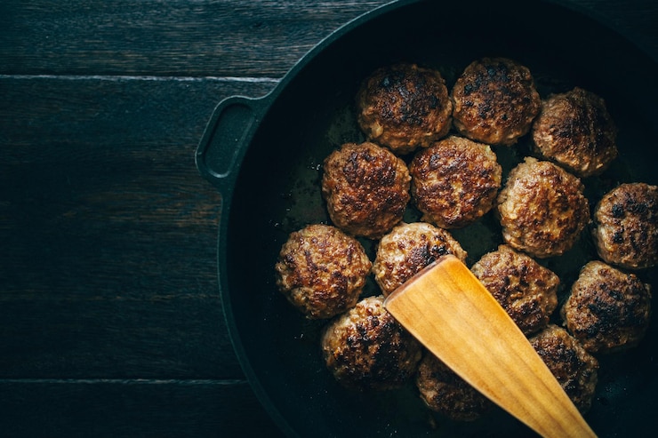 Photo spatula with meatballs in cooking pan