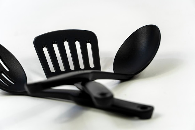 Spatulas and spoons black plastic on white background mexico