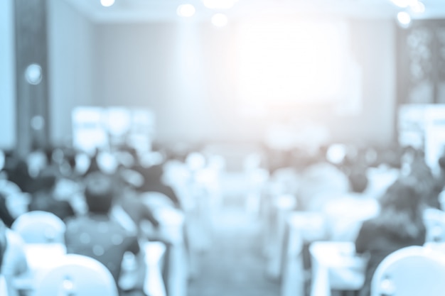 Speakers on the stage with Rear view of Audience in the conference hall 