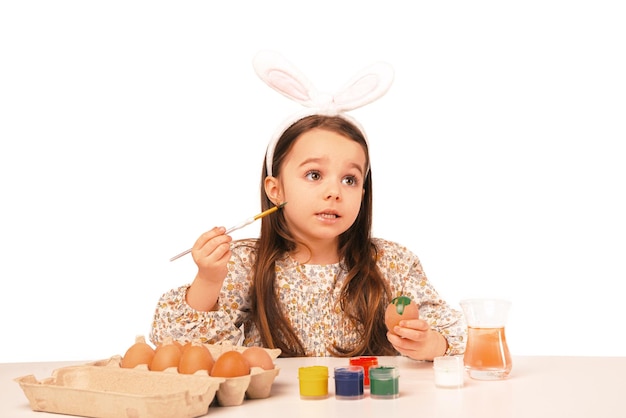 Speaking cute little girl is painting some eggs for the coming Easter