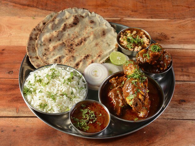 Special Chicken Thali van een Indiase keukenschotel bestaat uit Chicken curry linzen jeera rijst roti en uien selectieve focus