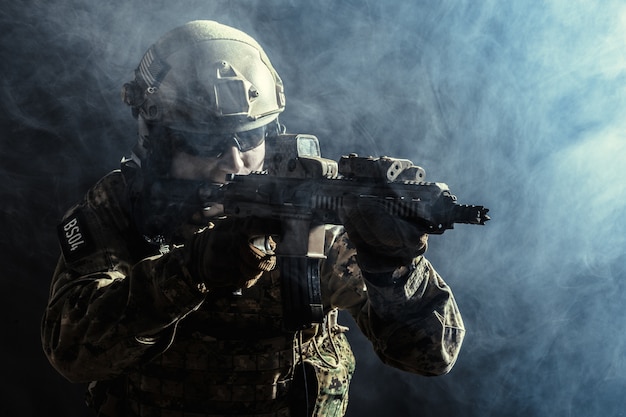 Special forces soldaat met geweer op donkere achtergrond