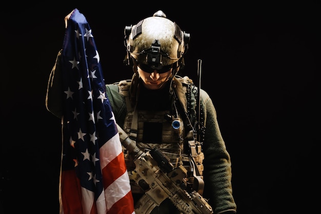 Фото Солдат спецназа держит национальный флаг сша в темноте