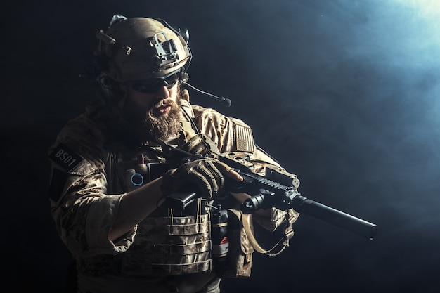 Special forces soldier with rifle on dark background