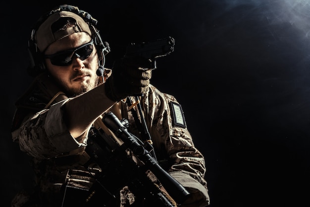 Special forces soldier with rifle on dark 