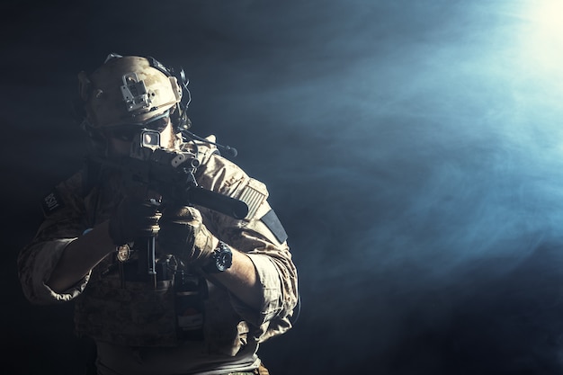 Special forces soldier with rifle on dark 