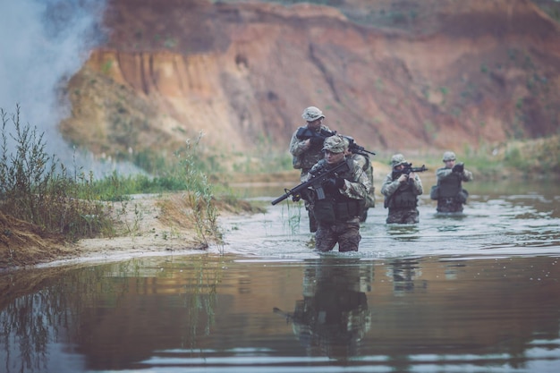 Special forces soldiers with weapon take part in military maneuver war army technology and people concept