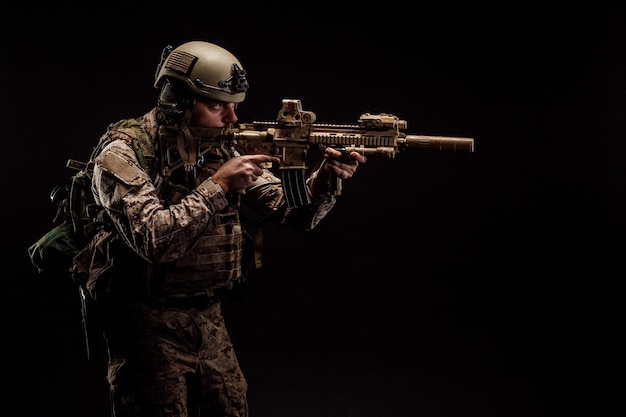 Special forces united states soldier or private military\
contractor holding rifle image on a black background