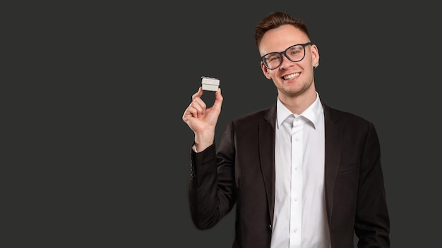 Special gift Promotional background Cheerful business man showing jewelry box smiling isolated on black copy space Romantic present Festive occasion