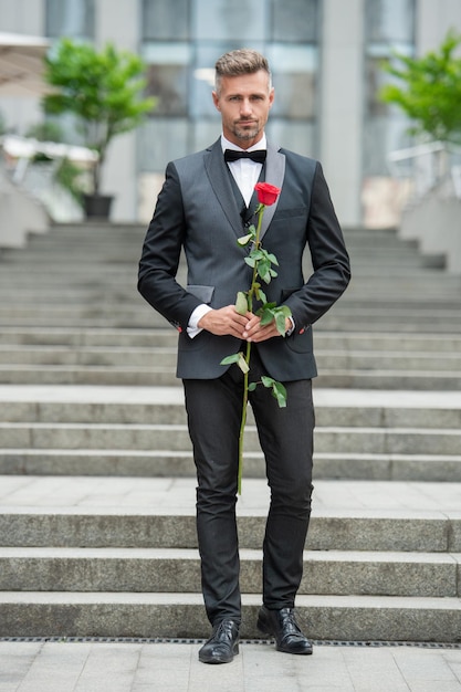 special occasion formalwear grizzle man with rose for special occasion tuxedo man outdoor at special occasion