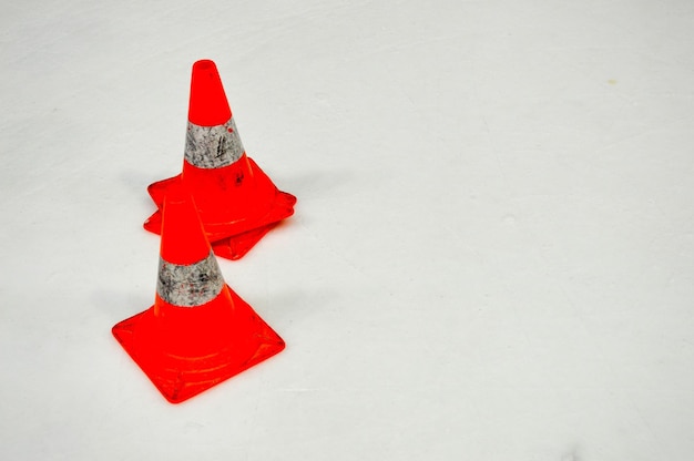 Photo special warning damaging plastic orange cones on white ice on ice hockey arena