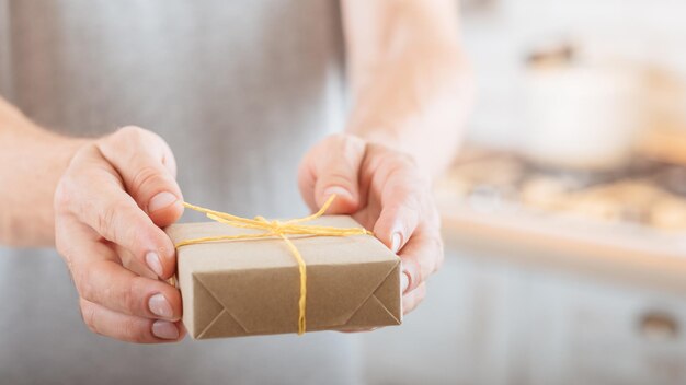 Speciale gelegenheid Close-up van handgemaakte rustieke stijl geschenkdoos in handen van de man Achtergrond vervagen