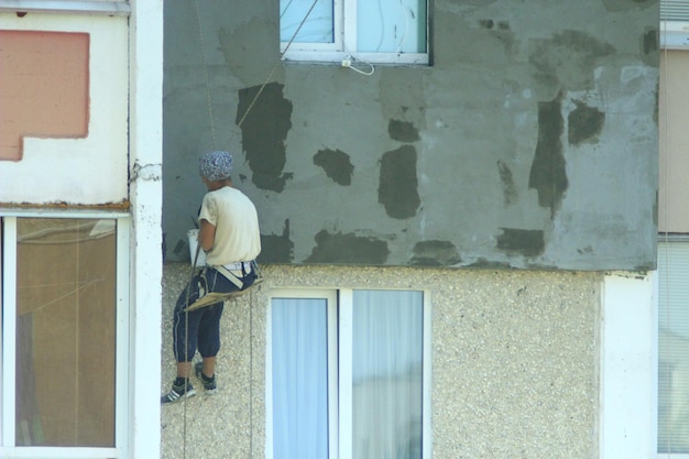 Photo specialist carring out warming of manystoried building on the height