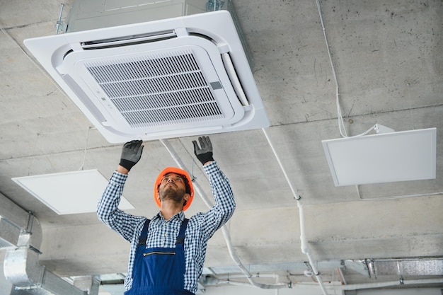 Specialist cleans and repairs the wall air conditioner
