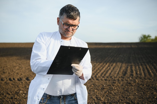 specialist die de kwaliteit van de bodem controleert vóór het planten en andere handholding, notitieboekje en penconcept, bodemverbetering voor de landbouw