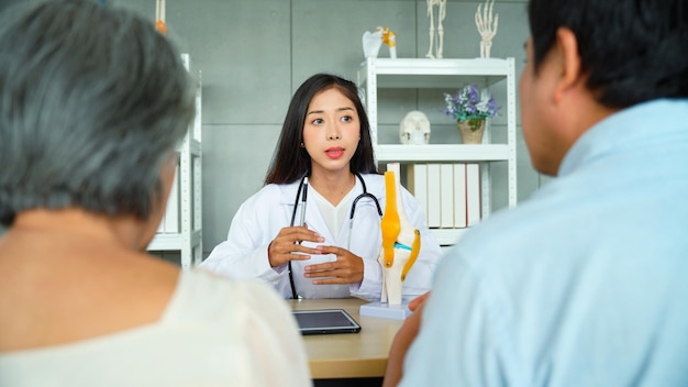 Specialist female doctor Explaining knee precautions and methods of treating the symptoms of elderly female patients