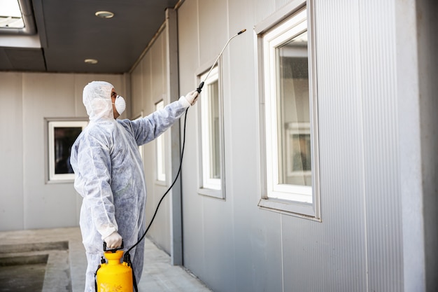 Specialist in hazmat suits cleaning and disinfecting coronavirus cells epidemic