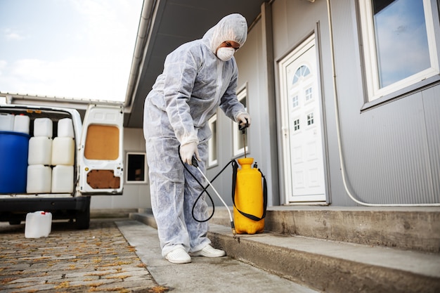 Specialist in hazmat suits preparing for cleaning and disinfecting coronavirus cells epidemic