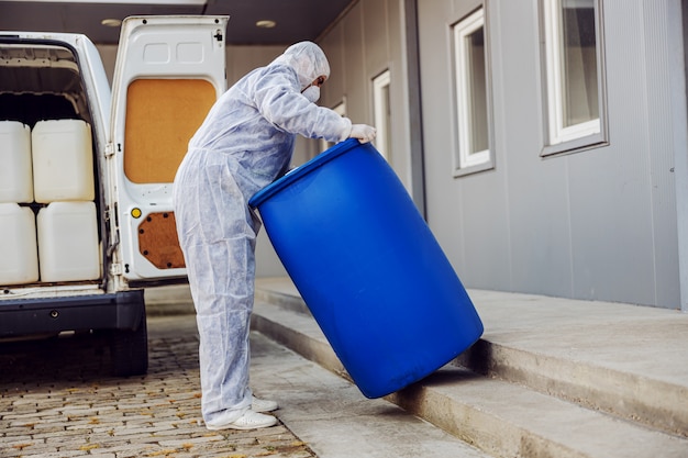 Specialist in hazmat suits preparing for cleaning and disinfecting coronavirus cells epidemic