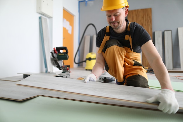 Specialist hold laminate in his handand put it on floor.