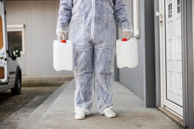 Specialist in hazmat-pakken die zich voorbereiden op het reinigen en desinfecteren van coronavirus-cellenepidemie