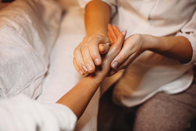 specialist is massaging client's hand with a solution