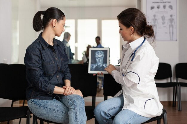 Specialist physician doctor showing radiography expertise to cheerful woman