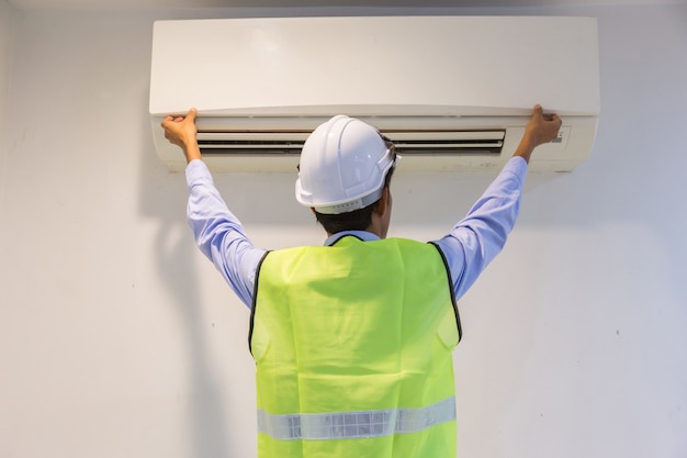 specialist reinigt en repareert de muur-airconditioner.