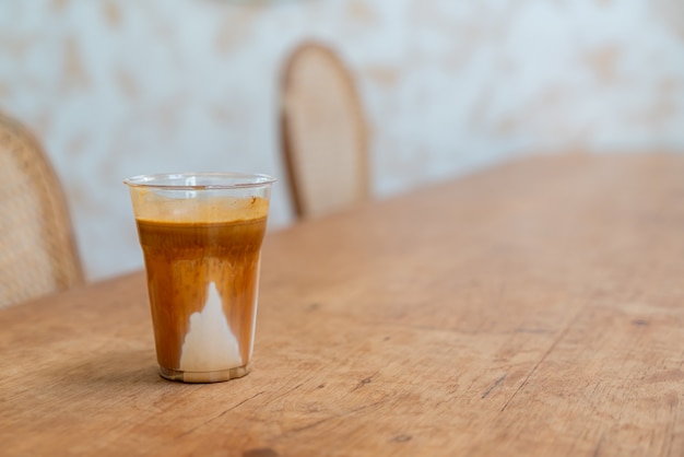 Фирменное кофейное меню под названием «Грязный кофе». Холодное молоко внизу с горячим эспрессо сверху в кафе, кафе и ресторане