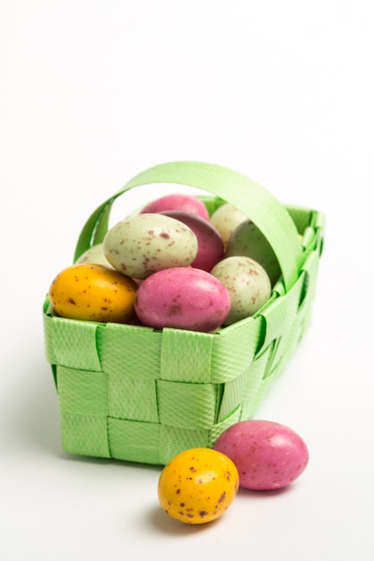 Speckled colourful easter eggs in a green wicker basket