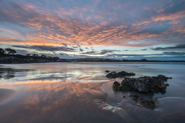 spectaculaire reflecties van de zonsondergang op het strand van Arnao