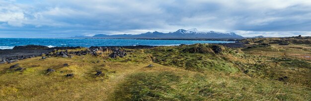 Захватывающий вид на черное вулканическое скалистое побережье океана с мыса Ондвердарнес — самой западной точки полуострова Саефелльснес в Западной Исландии.