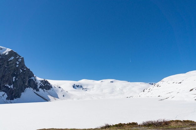 Spectacular frozen and snowy lake with surrounding snowcapped mountains in Norway