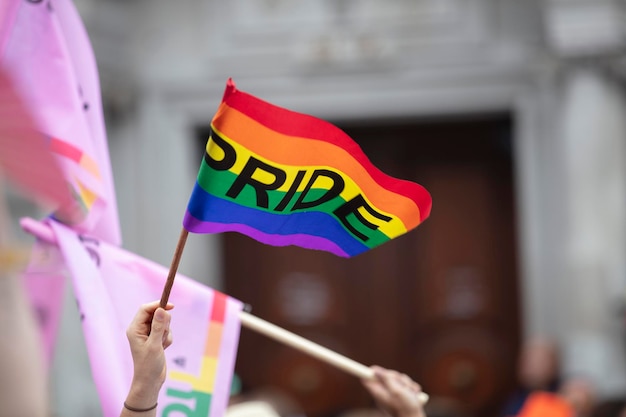 A spectator waves a gay rainbow flag at an lgbt gay pride march in london