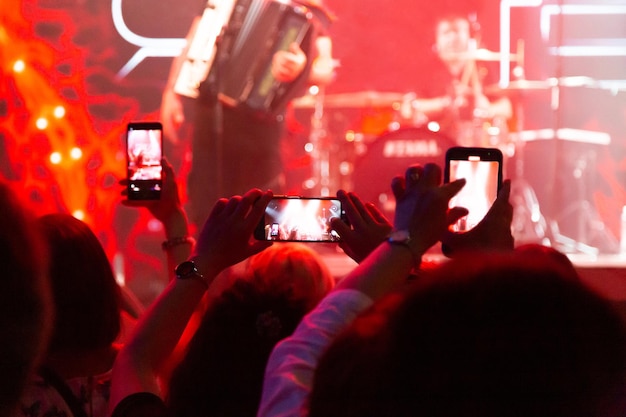 Gli spettatori vicino al palco riprendono il loro artista preferito su uno smartphone